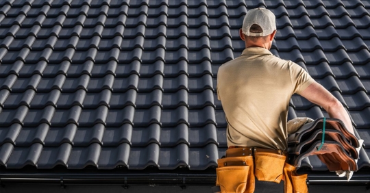 professional roofer standing in front of metal roof