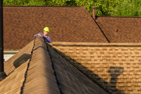 man in hard hat inspecting a roof